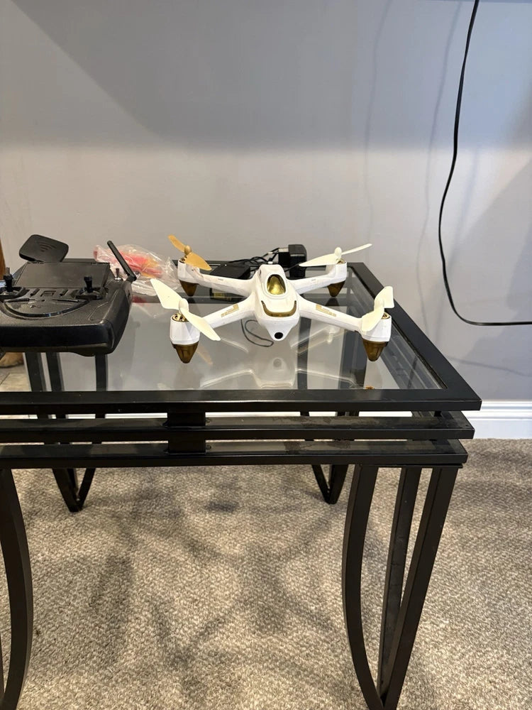 White quadcopter drone with four propellers and landing gear