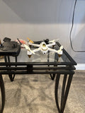 White quadcopter drone with four propellers and landing gear