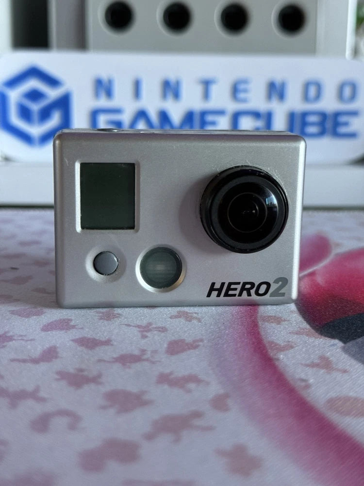 GoPro HERO2 action camera front view with lens, small screen, and silver body