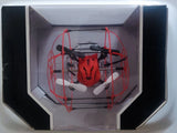 Mini red quadcopter drone with propeller guards in display box