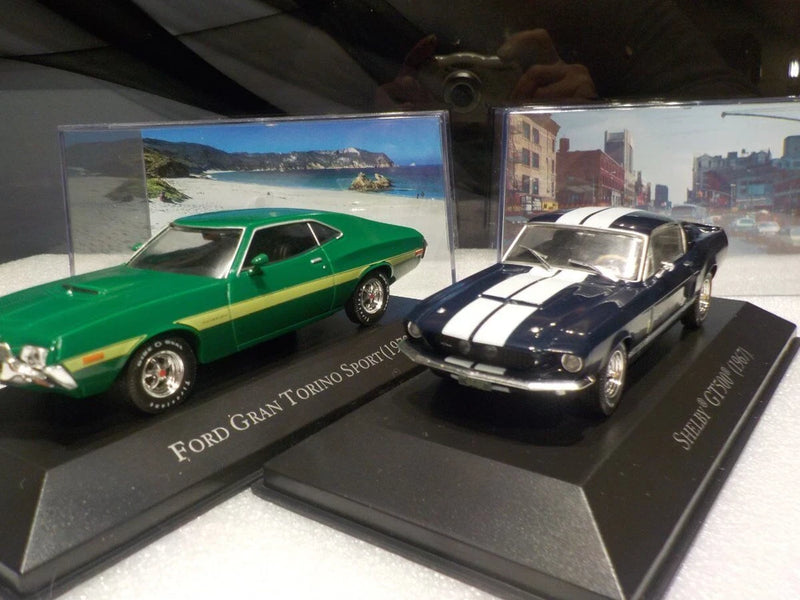 1/43 die-cast model car set: green Shelby GT500 and black Gran Torino, display base