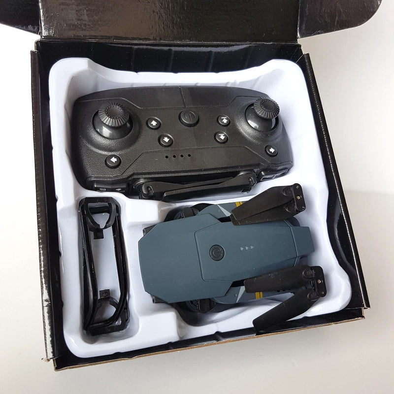 Used quadcopter drone with controller, spare parts, and charger in open box
