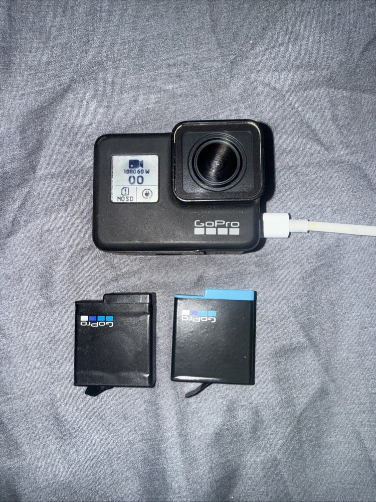 GoPro Hero7 Black action camera with lens, two batteries, and white cable