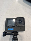 Black GoPro HERO action camera with waterproof touchscreen and front lens, on mount