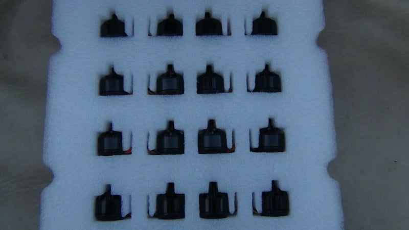 Set of 16 black motor housings on blue foam insert