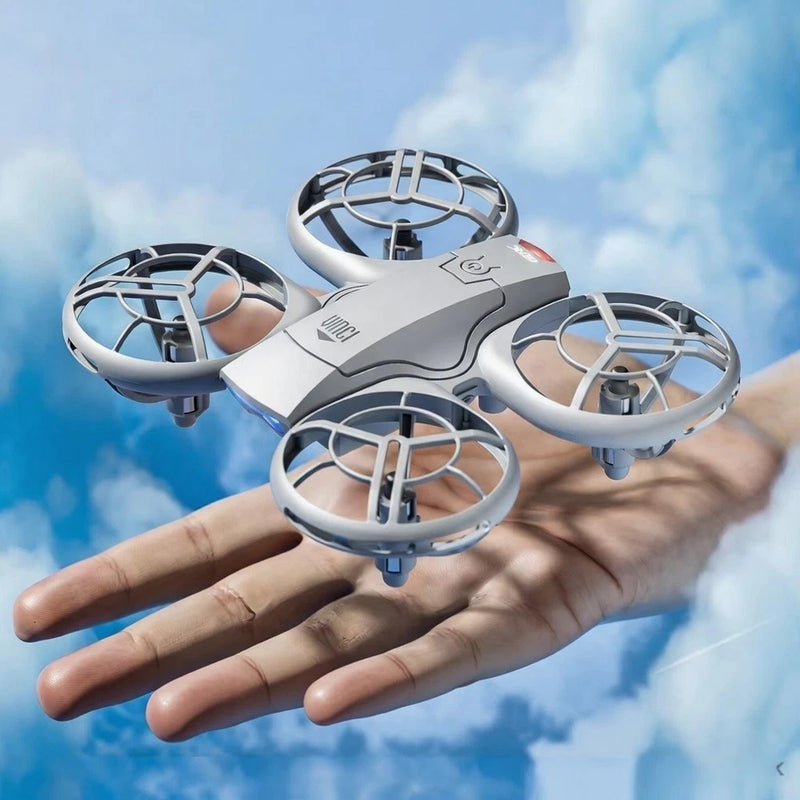 Silver mini FPV drone with four propeller guards, held in a hand