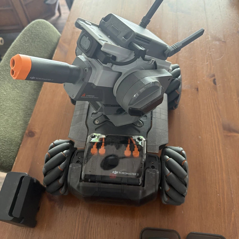 RoboMaster S1 robot with gray body, orange accents, front display screen and grippers