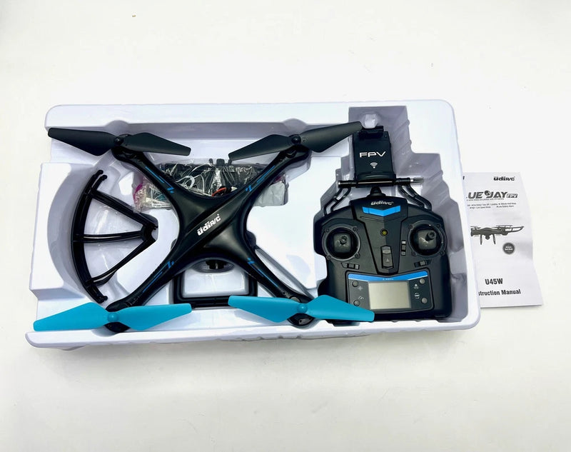 Black FPV quadcopter drone with attached FPV camera module and props on tray