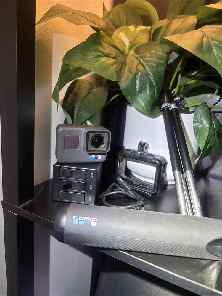 GoPro action camera bundle with LCD camera, waterproof case, mounts, and tripod pole