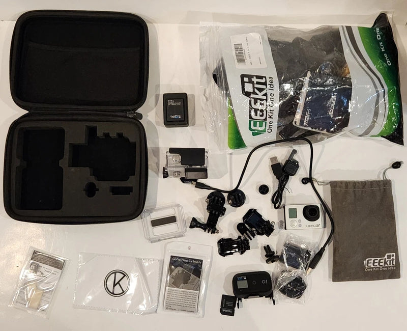 Silver action camera in open case with mounts, cables, and extra accessories