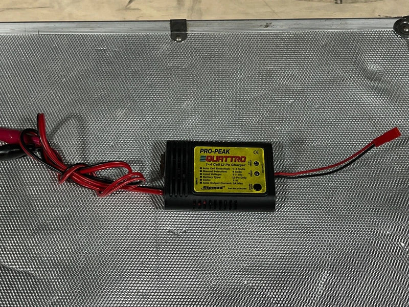 Black field charger with yellow PRO-PEAK QUATTRO label and red/black connector wires