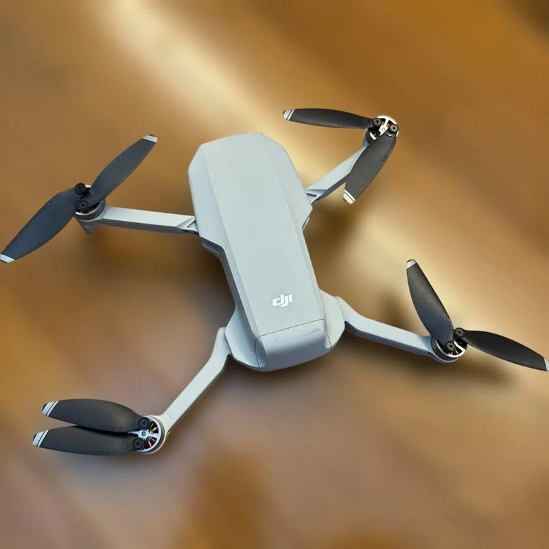 Dji Mavic Mini compact drone with four propellers, light gray body