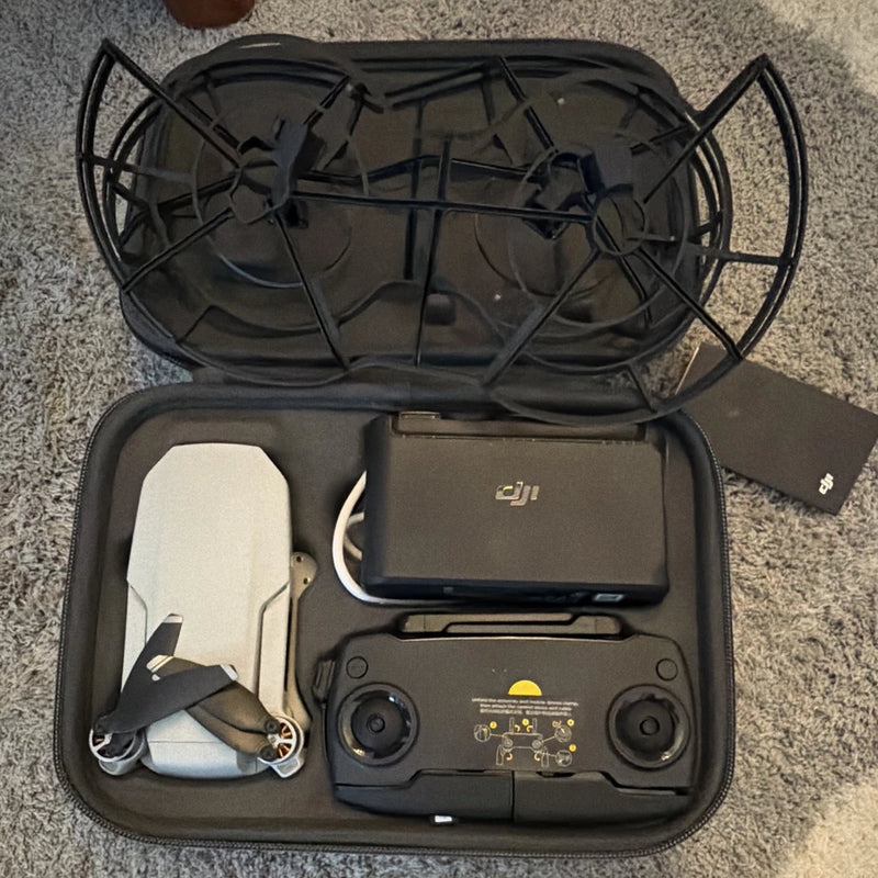 Ready-to-fly drone kit in open case with controller, charger hub, and cables