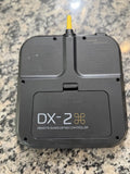 Black DX-2 remote quadcopter controller with yellow antenna, rear button ports visible