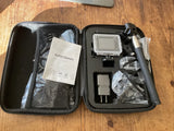 Action camera kit in zip case with waterproof camera housing and included accessories