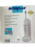 Handheld plaque removal instrument in retail box, showing gray device and brush heads.