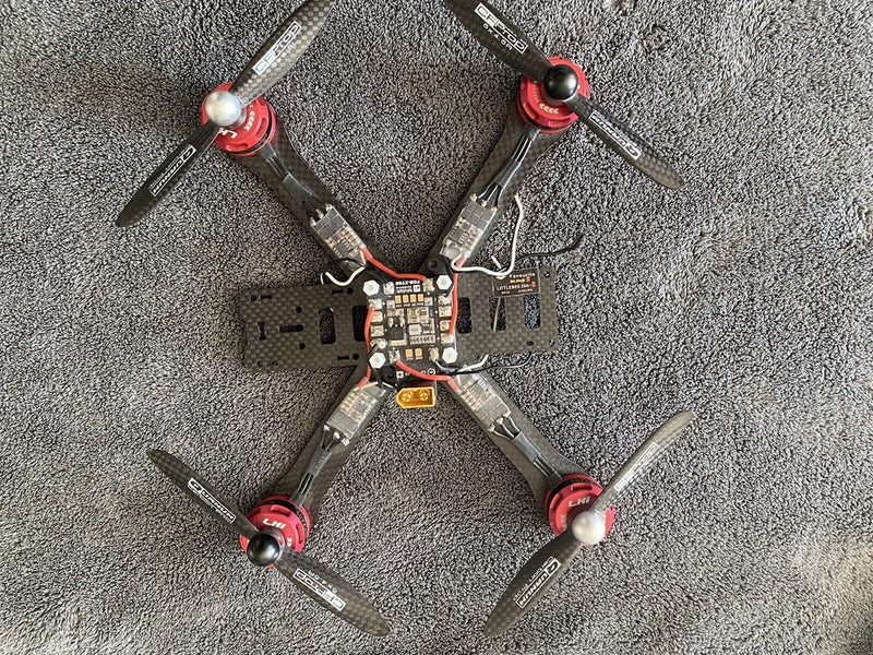 Quadcopter drone with four propellers and central circuit board controller