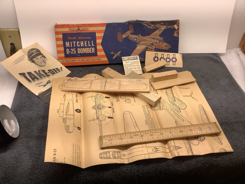 Vintage balsa bomber model kit with pre-cut parts, instruction diagrams, and templates