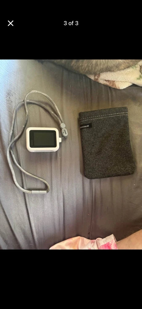 White action camera in housing with lanyard cord and gray carry pouch