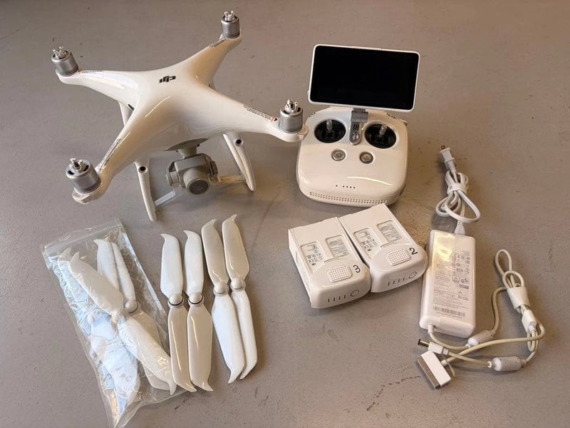White quadcopter drone with controller and charging accessories