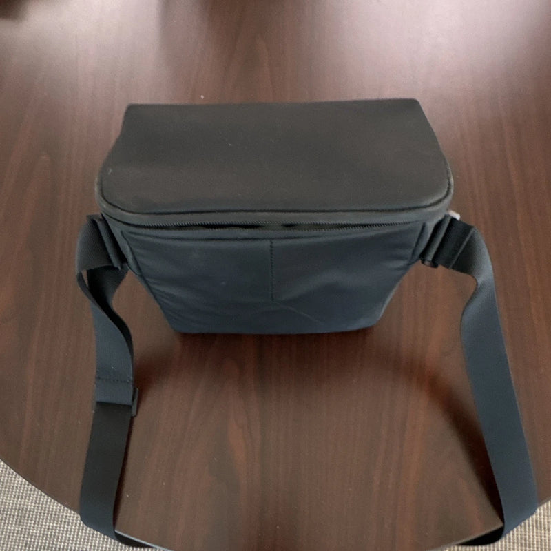 Black drone shoulder bag with zippered top and adjustable strap