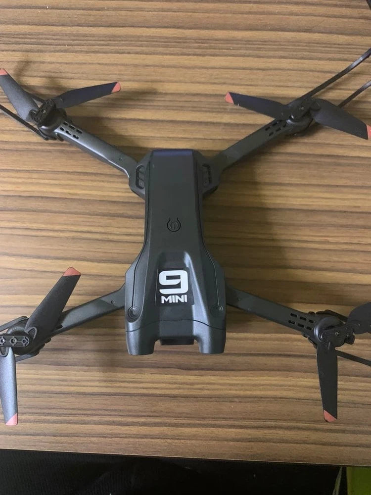 Mini RC quadcopter drone with four dark propellers and gray body