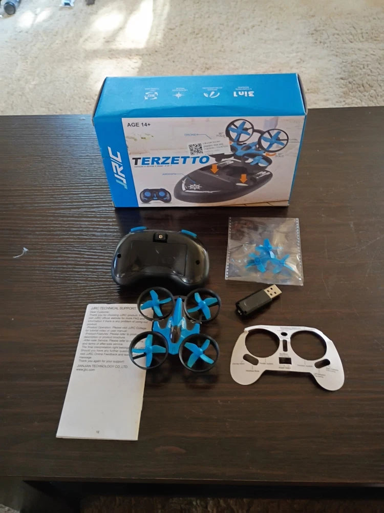 RC quadcopter drone kit with blue propellers, controller, and USB receiver, in box
