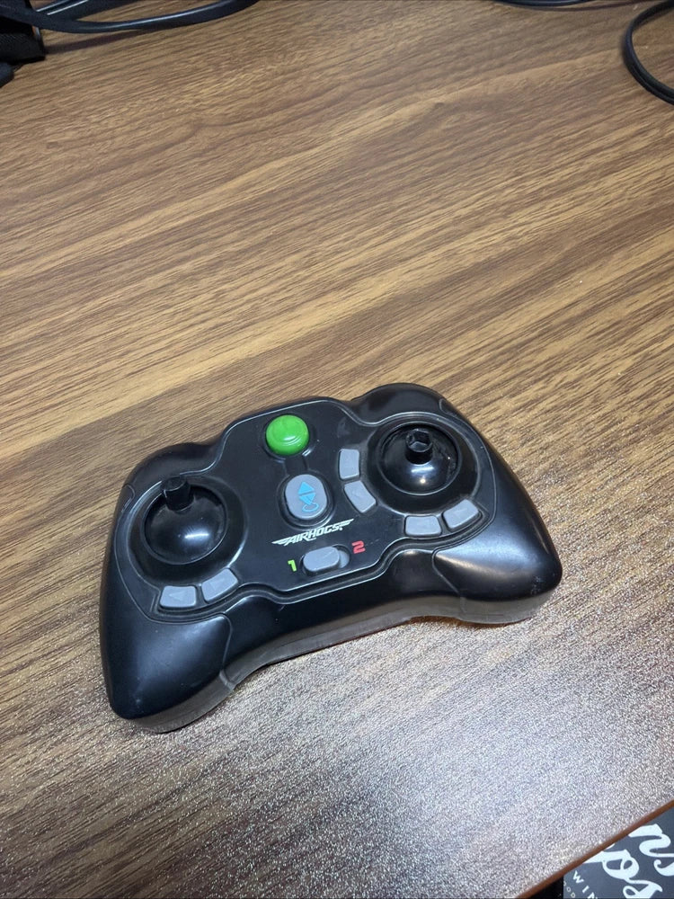 Black racing drone remote controller with green indicator and thumbsticks