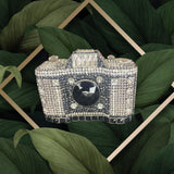 Silver rhinestone camera clutch with black lens detail and rhinestone clasp