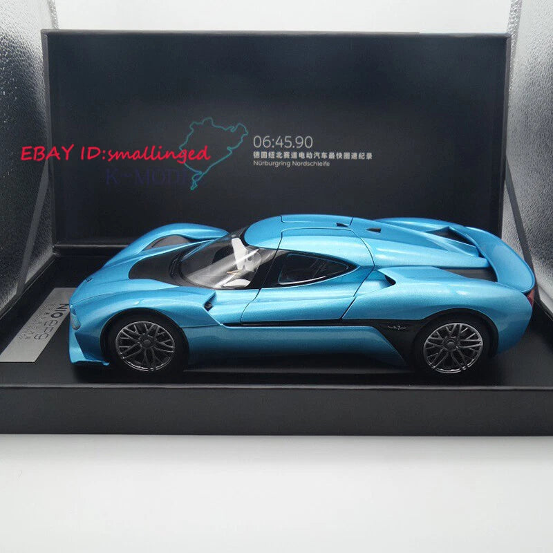 Blue 1:18 sports car model with rear wing in a display case