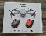 Folding dual-camera quadcopter drone, gray body with orange and black folded units