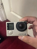 GoPro HERO4 action camera with front lens and small screen, gray body
