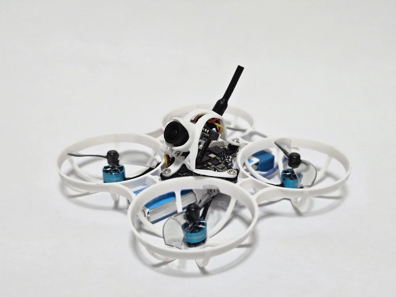 White FPV quadcopter drone with four propellers, camera module, and antenna