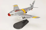 Gray F-86F jet model with yellow and red markings on dark display stand