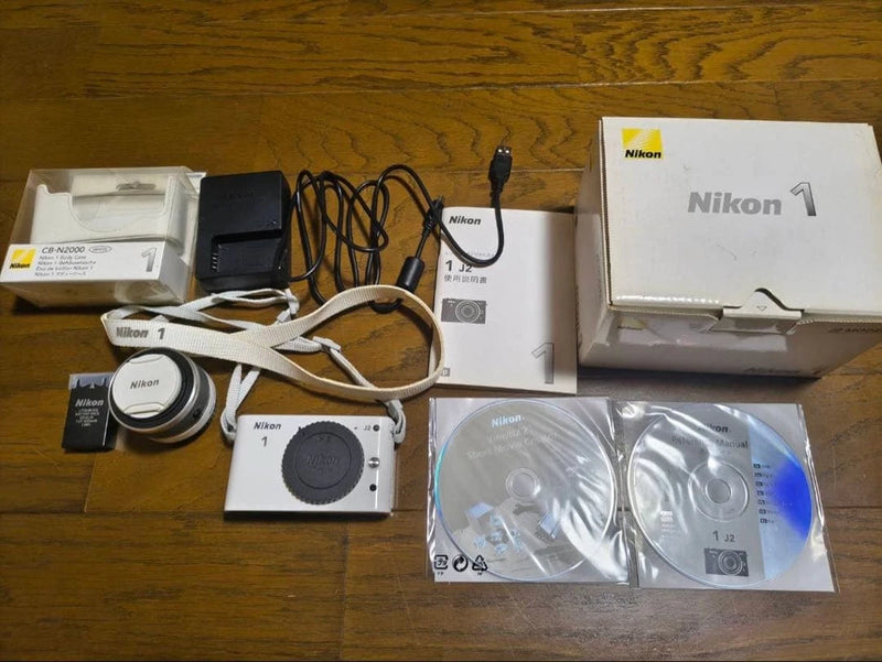 White Nikon 1 J2 digital camera kit with lens, box, cables and accessories