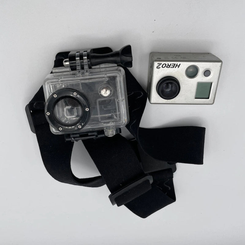 Action camera in clear waterproof housing with black head strap mount and body unit