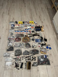 Drone builder parts lot with motors, ESCs, frames, and wiring accessories in sealed bags