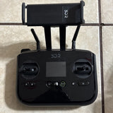 Black remote controller with two antennas, LCD screen, and control sticks
