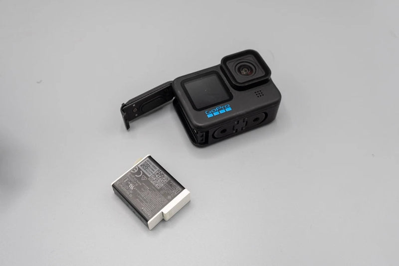 Black GoPro action camera with front lens, screen, and battery pack