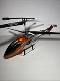 RC helicopter with orange-and-black body, main rotor, tail boom, and landing skids