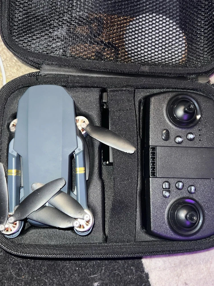 Foldable toy quadcopter drone and controller in open gray carry case