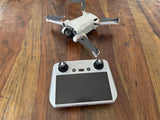 White drone controller with two black precision control knobs and screen