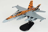 Gray jet fighter scale model with orange tiger-stripe markings on black display stand