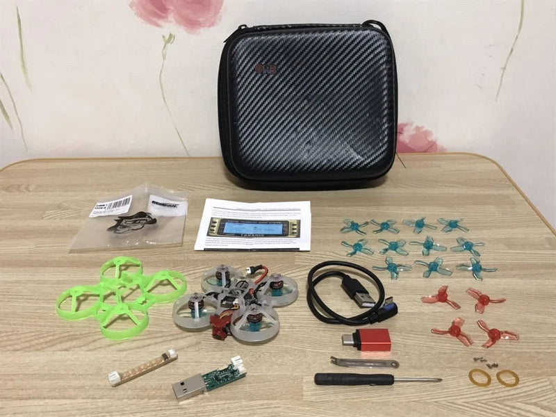 Micro RC drone parts set with black hard case, propellers, circuit boards, cables