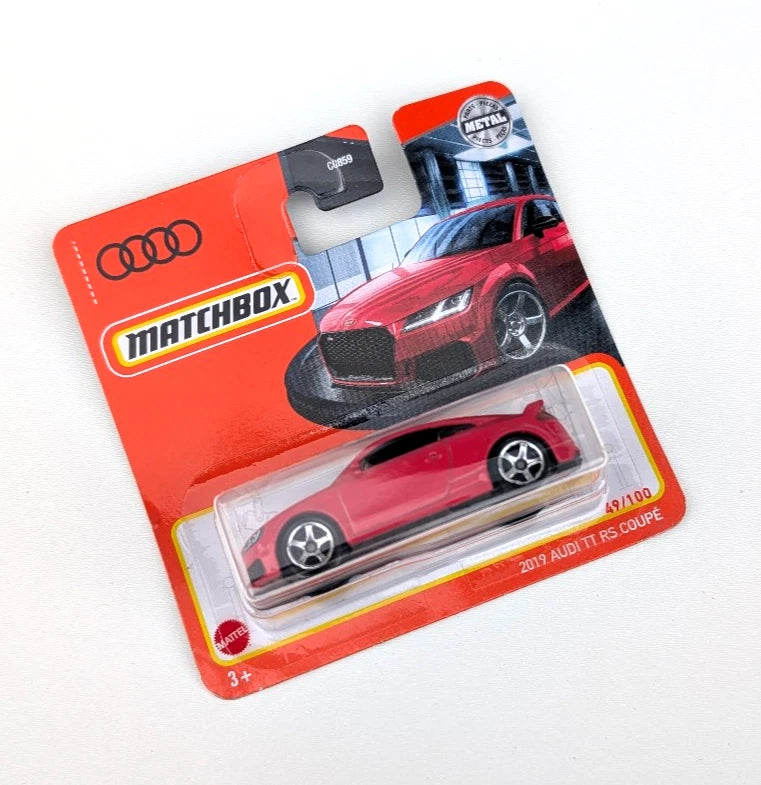 Red die-cast Audi TT RS Coupe model car in Matchbox blister package, front view.