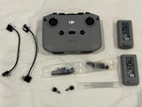 Drone remote controller with DJI branding, two batteries, cables, and accessories