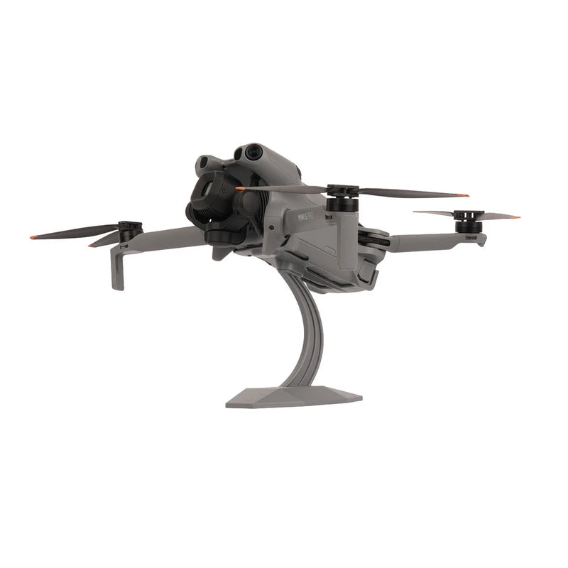 Desktop drone display stand with mounted gray quadcopter and curved support base