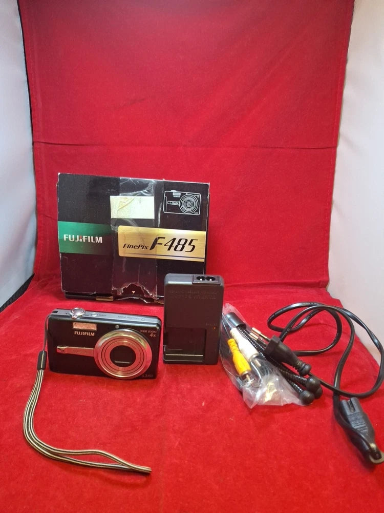 Red compact Fujifilm FinePix F485 digital camera with accessories on display