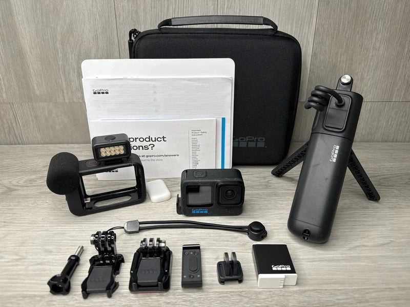 GoPro action camera bundle with camera, mounts, mic, grip/tripod, batteries, and carrying case