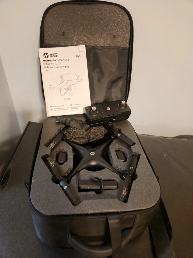Black quadcopter drone resting in padded hard case with instruction sheet